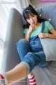 A woman sitting on a couch with her legs crossed.