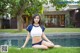 A woman in a blue and white bikini sitting by a pool.