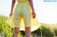 A woman in a yellow dress standing in a field.