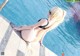 A woman in a black and white bikini sitting by a pool.