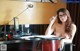 A naked woman sitting at a desk in front of a computer.