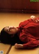 A woman in a red shirt laying on the floor.