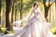 A woman in a wedding dress standing in the woods.